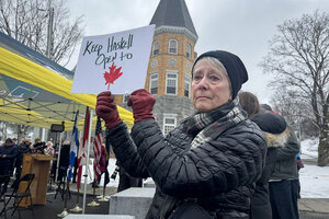 A woman holds a sign in support of Canadians visiting the Haskell Free Library & Opera House, which sits on the U.S.-Canada border. 