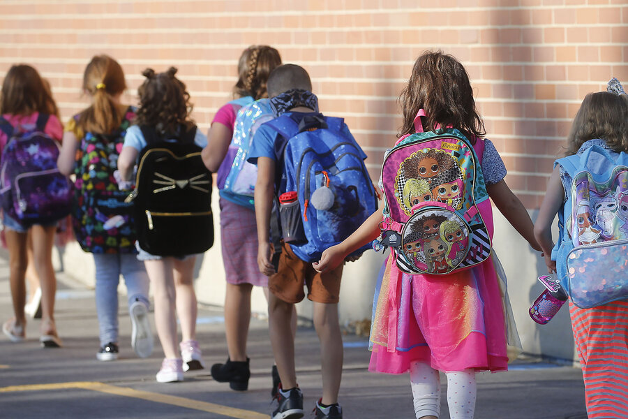 Students wearing backpacks walk into Liberty Elementary School in Murray, Utah, in 2020