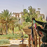 A Sudan army soldier holds a national flag to celebrate after the army took over the Republican Palace in Khartoum, Sudan.