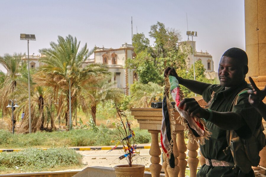 A Sudan army soldier holds a national flag to celebrate after the army took over the Republican Palace in Khartoum, Sudan.