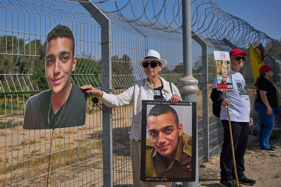 A woman holds a large picture of Edan Alexander, who has been held hostage in Gaza.