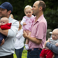 Fathers hold their babies at a Fourth of July parade in 2021 in Hingham, Massachusetts. A movement to encourage people to have more children has made its way into the Trump administration's budget bill now under consideration. 