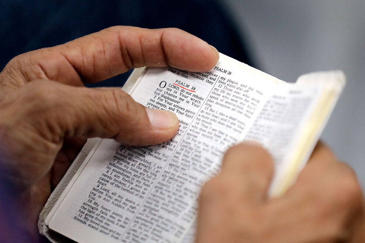 A man holding a Bible during a church service in Cypress, Texas