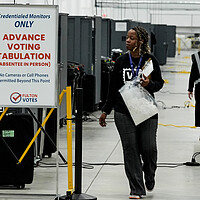 An election worker walks near voting machines at the Fulton County Election Hub and Operation Center, Nov. 5, 2024, in Atlanta.